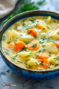 a blue bowl filled with potatoes and carrots