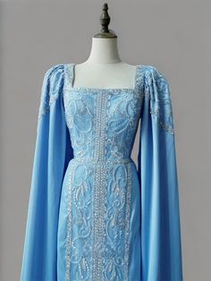 a blue dress on a mannequin dummy with an open cape over it's shoulders