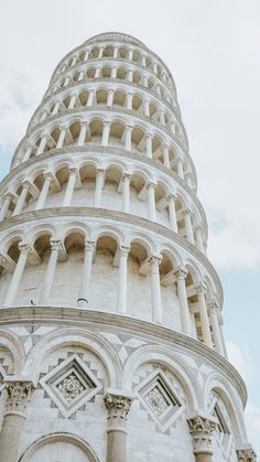 the leaning tower of a building with white pillars and arches on it's sides