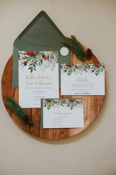 the wedding stationery was done with greenery, pine cones, and red berries