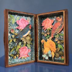 an open wooden box with flowers and birds in it