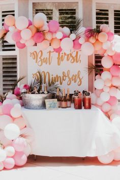 a table topped with lots of pink and white balloons next to a sign that says, but first princess