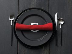 a black plate with a red napkin on it and silverware in front of it that says napkin holders made easy