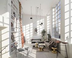 a living room filled with furniture and large windows