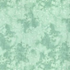 a green wallpaper with white flowers and swirls on the back ground in an ornate pattern