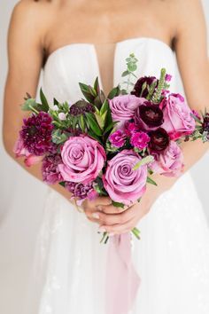 a woman holding a bouquet of flowers in her hands