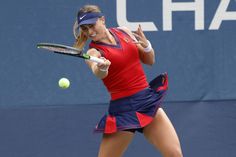 a woman hitting a tennis ball with a racquet