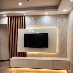 a tv mounted on the wall in a living room with white walls and marble flooring