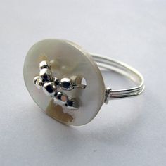 a silver ring with an animal on it's center and two balls in the middle