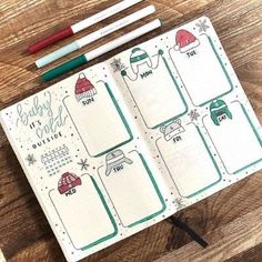 an open planner with christmas themed pages and pencils next to it on a wooden table