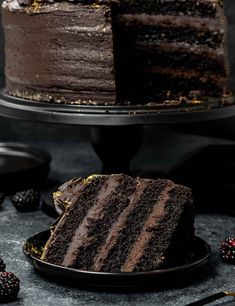 a slice of chocolate cake on a plate with raspberries next to the cake