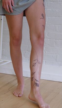 a woman's legs with tattoos on them