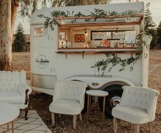 the interior of an rv is decorated with greenery and white furniture, including chairs