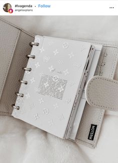 an open planner book sitting on top of a bed