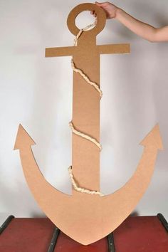 an anchor made out of cardboard is being held up by a person's hand