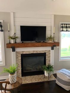 a living room with a fireplace and television on top of the mantel above it