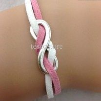 a close up of a person's arm wearing a pink and white leather bracelet