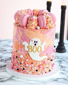 a decorated birthday cake with sprinkles and pink frosting on it's side