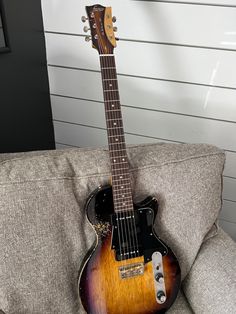 an electric guitar sitting on top of a couch