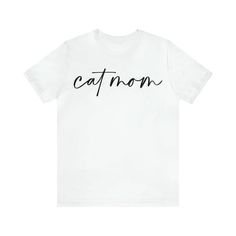 Show your love for your feline friends with our stylish and comfortable Cat Mom t-shirt! Made from high-quality materials, this shirt is perfect for cat lovers who want to show off their love for their pets in style. The graphic script cool font of the words "Cat Mom" adds a playful touch to your wardrobe, while the soft and breathable fabric keeps you comfortable all day long. Whether you're lounging at home with your cats or out and about running errands, this t-shirt is a perfect choice. The Dog And Cat Mom Shirt, Funny Cat Maternity Shirts, Cool Font, Word Cat, Cat Mom Shirt, Pink Dog Dress, Cheap White T-shirt With Cat Print, Cat Mom Shirts, Pet Sweater