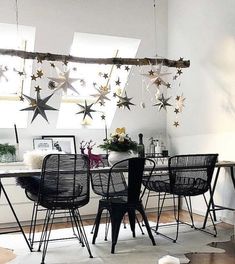 a dining room table with four chairs and hanging stars