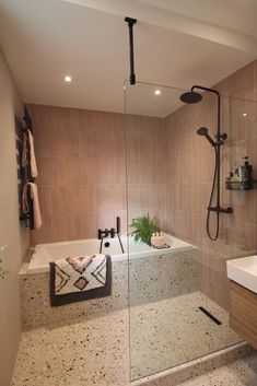 a bathroom with a bathtub, sink and shower head mounted to the side of the wall