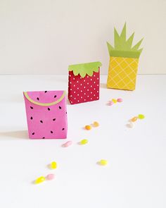 three paper bags with strawberries and pineapples on the top one is pink