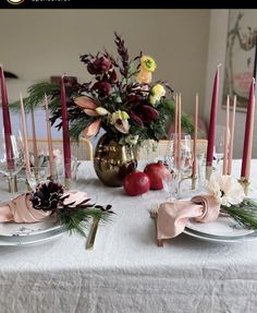 the table is set with candles, flowers and fruit for an elegant holiday dinner or special occasion