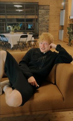 a woman sitting on top of a brown couch