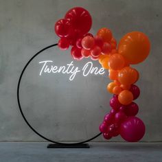 there is a neon sign that says twenty one on the wall and balloons hanging from it