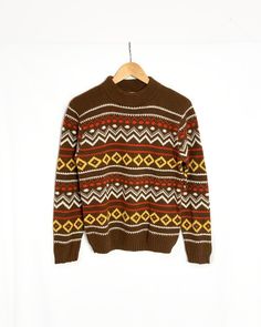 Cozy vintage sweater with bold pattern and mock neck. Excellent condition with light pilling and no obvious flaws. Label: Mustang Fabric: 100% orlon acrylic Marked size: -- Best fits: men's small Chest 38 inches Length 24.5 inches Shoulders 16.5 inches Sleeve 24 inches  Hips 32 inches Retro Brown Sweater For Fall, Retro Fall Sweater, Retro Brown Top For Winter, Retro Brown Winter Top, Retro Fair Isle Pattern Winter Tops, Retro Jacquard Knit Winter Tops, Winter Retro Jacquard Knit Tops, Retro Jacquard Knit Sweater For Fall, Vintage Patterned Winter Sweater