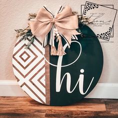 a black and white sign with a bow on it that says hi in front of a wall