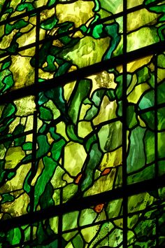 a large stained glass window with green leaves on it