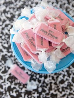 pink and white candies in a blue bowl on a black and white tablecloth