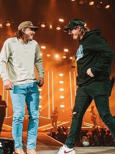 two young men standing on stage talking to each other