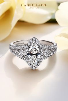 a diamond engagement ring on top of a white flower