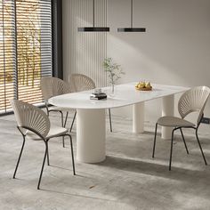 a white table with four chairs around it in a room that has blinds on the windows