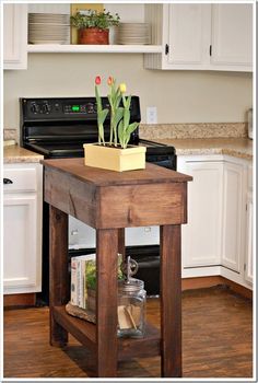 a kitchen with white cabinets and an island that has flowers on it in the center