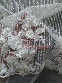 "This stunning Lace Fabric design piece has soft hand feel, It's perfect for weddings, bridal parties, and any events. Shop our large inventory of bridal fabrics. ☆PRODUCT DESCRIPTION : This gorgeous fabric is made on a sheer base with a beautiful flower embroidery and delicate beaded throughout. The fabric width is approximately 51\" (130cm) Wide. Color: off white or beige as in picture Material: Rayon, Polyester, Pearls, Sequins ☆ PURCHASING INFORMATION: This fabric is sold by the yard and eac White Tulle Gown With Pearl Embroidery, Wedding Dress With 3d Embroidery In Organza, Cream Wedding Dress With Floral Applique, Elegant White Gown With Floral Applique, Wedding Tulle Dress With 3d Flowers, Wedding Dresses With 3d Flowers And Tulle, Wedding Dress With 3d Flowers In Tulle, White Bridal Dress With Pearl Embroidery, White Bride Dress With Pearl Embroidery