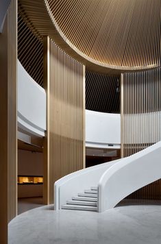 a spiral staircase in the middle of a building with wooden panels on it's walls