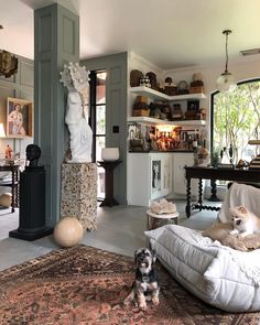 a living room filled with furniture and a dog sitting on the floor next to it