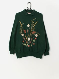 Vintage forest green collared sweatshirt with embroidered field mouse and flowers. This 90s forest green sweatshirt features an embroidered field mouse and butterfly surrounded by colourful wild flowers on the front and a single field mouse on the back. This sweatshirt also features a collared neck, long sleeves, a super cosy fleece lining and is made in from a heavyweight soft cotton blend.  Our recommended size: Large to XL Label says: No size label Condition: Very good Material: 65% acrylic, Field Mouse, Vintage Forest, Green Sweatshirt, Collared Sweatshirt, Size Label, Fall Style, Forest Green, Wild Flowers, Sweatshirts Women