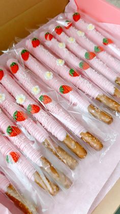 a box filled with donuts covered in pink frosting and strawberries on them