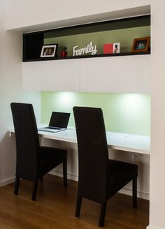 two black chairs sitting in front of a white desk