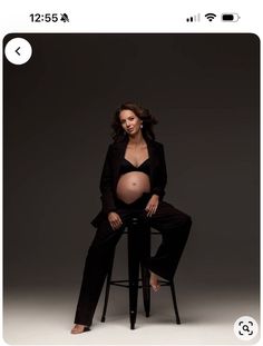 a pregnant woman sitting on top of a stool in front of a black background with an instagram