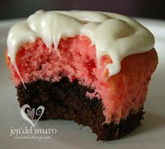 a chocolate and red velvet cake with white frosting on it's top half