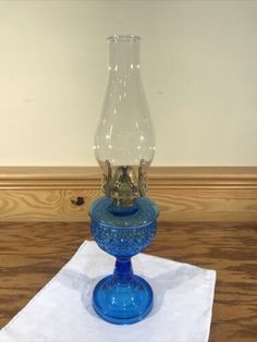 a blue glass vase sitting on top of a white napkin