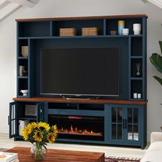 a living room with a large entertainment center and fire place in the fireplace, it is dark blue