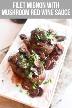 two pieces of meat covered in mushrooms and garnished with parsley on a white plate