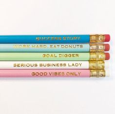 four pencils with writing on them sitting next to each other